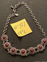 Full view of the vintage red stone choker necklace arranged on a flat surface with a yellow note showing "#51 14" L" indicating the lot number and length of the necklace.