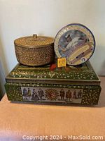 Three vintage tins stacked: green rectangular with historical figures, blue Jays baseball round tin, and brown textured round tin with lid.