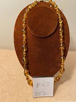 Full view of the necklace displayed on a stand with a note showing "#65 26" L" indicating the length of 26 inches.