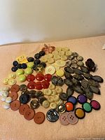 Wide angled image showing full lot of vintage buttons assorted by color and shape on a flat surface