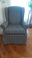 Front view of the upholstered armchair showing blue and beige vertical stripes and wingback style.