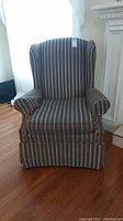 Front view of the wingback armchair showing striped fabric and rolled arms.