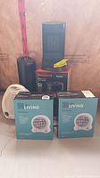 Photo showing two Living fan heaters in sealed boxes, honeywell tower heater with box and unboxed Sunbeam heater
