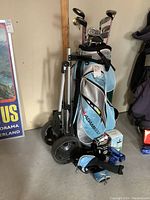 Full lot view showing Adams Golf bag, push cart, clubs and accessory boxes