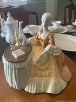 Front view of Royal Doulton Meditation figurine seated at desk with book and candlestick.