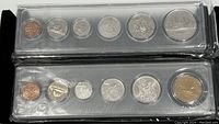 Two uncirculated Canadian coin sets from 1980 and 1989 in plastic packaging, each with six coins aligned in a row.