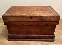 Front elevation of closed wood chest showing overall form and finish