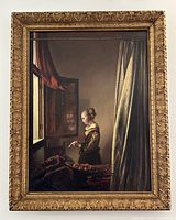 Front view of framed painting depicting girl reading a letter at a window, ornate carved gilt frame.