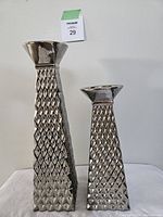 Front view showing two silver-toned, painted pottery candle holders with diamond textured pattern, tapered shape.