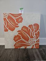 Front view of the square canvas print with large orange hibiscus flower on off-white background.