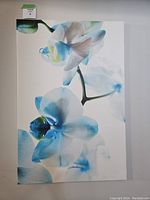 Front view of large wrapped canvas print featuring blue orchids, displaying the artistic floral design and colors.