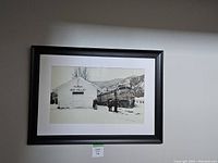 Framed black and white print of Union Pacific Railway train and Sun Valley building, displayed on a light grey wall.