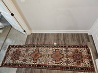 Full view of the Kilim runner rug laid flat on wood floor showing overall pattern and condition.