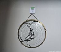 Photo of the suncatcher hanging on a wall with chain visible