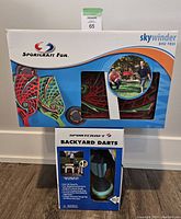 Closed boxed Skywinder Disc Toss and Backyard Darts stacked on top of each other.