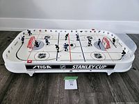 Full view of STIGA NHL Stanley Cup table hockey game on floor with players and nets in place