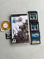 Photo shows a Dissidia Final Fantasy PSP UMD game in case, two Game Boy Advance cartridges labeled Quest games, and three Nintendo DS cartridges including Sudoku.