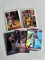 Five sports cards arranged on a white surface: four basketball cards and one football card. Basketball cards show dynamic action shots; football card has holographic effects and displays Jaylen Waddle.