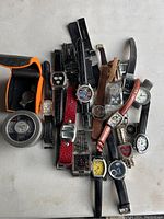 Collection of various wrist watches seen from above on a flat surface