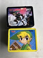 Top view of two Zelda lunch boxes showing the character Link, one for Nintendo Wii and the other for Nintendo DS