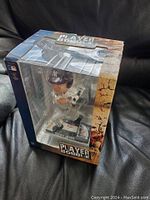 Clear view of the bobblehead figure in its box with 'Player Bobble' branding visible on packaging.