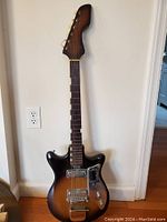 Front full view of electric guitar showing double-cutaway body and sunburst finish