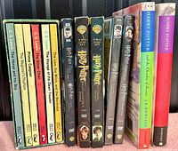 Side view of the boxed set of seven Puffin paperback Chronicles of Narnia books displayed next to five Harry Potter DVDs and two hardcover Harry Potter novels with dust jackets.