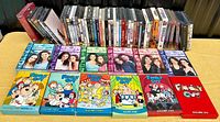Photo showing entire DVD collection with Family Guy volumes 1-6 and Gilmore Girls seasons 1-6 prominently displayed in front, with additional DVDs arranged behind them.