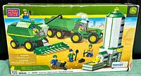 Front of the Mega Bloks John Deere Harvest Crew kit box showing graphics of the assembled combine harvester, tractor with trailer, grain silo, and five farm worker figures on farmland background.