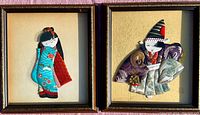 Two framed Japanese Oshie silk figures showing a woman in turquoise kimono and a male figure in striped hat and patterned robes.