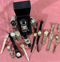 Photo showing 13 assorted wristwatches in various styles and straps.