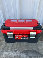 Front view of Craftsman toolbox showing red lid, black base, metal latches, and handle.