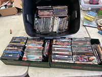 Photo showing three containers filled with DVDs including titles such as Lawless, Wagon East!, and several others.