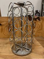 Front angle view of chrome metal cylindrical Keurig K-Cup pod holder carousel showing circular pod slots and rotating base.