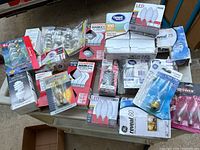Top down photo showing many unopened light bulb packages in various sizes and types spread on table