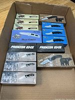 Box with various Frost Cutlery knives including Running Bear, Delta Ranger, Premier Edge, The Tracker, Avenue Skinner