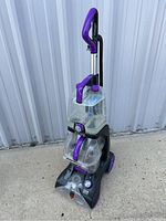 Hoover Elite steam cleaner upright, black and gray plastic body with clear water tanks and purple handle and knobs.