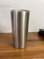 Yeti stainless steel cup full view showing shape and finish on wooden surface