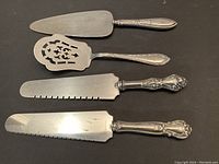 Four-piece set of sterling silver-handled service ware with stainless steel blades.