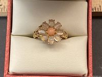 Top-down view of ring in presentation box showing floral gemstone arrangement