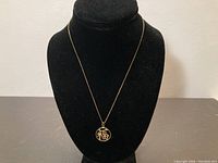 Full view of necklace with pendant displayed on black jewelry bust.