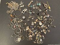 Top-down view of all sterling silver jewelry parts spread on black background