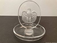 Front view of clear Lalique glass ring dish with raised eagle and 1776-1976 inscription