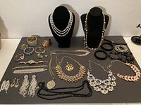 Three-strand crystal AB bead necklace and various bracelets on gray surface