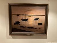 Full view of framed painting showing sailboats on calm water at sunset