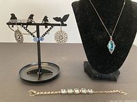 Group shot of earrings, ring, bracelets, and necklace pendant on bust showing entire lot
