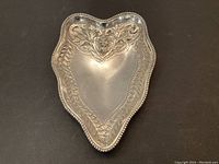 Top view of the sterling silver dish showing detailed embossed leaf and floral design with a beaded edge.