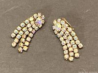 Front view of both earrings showing cascading strands of aurora borealis rhinestones and central larger rhinestone on each earring.