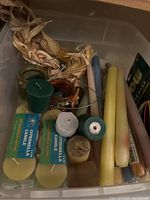 Top-down view of assorted candles including citronella and taper candles along with red wine stoppers