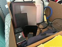 Box containing leather portfolios and organizers, magnifying glasses, and some boxed items